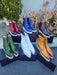 Assorted colorful boots in outdoor setting (blue, green, white, tan)